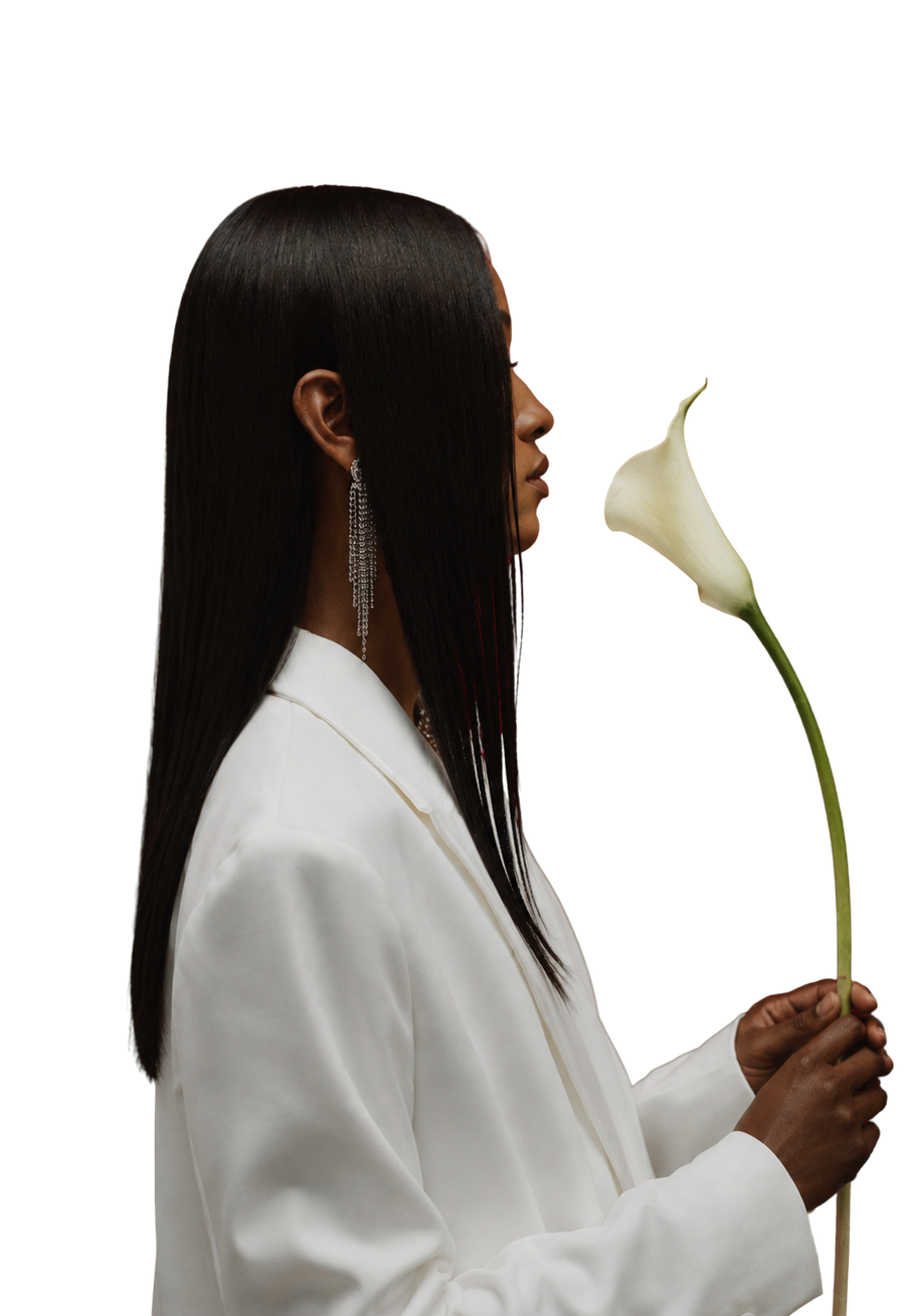 A woman in a white suit holding a calla lily